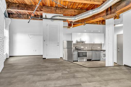 A kitchen area with a washing machine and a refrigerator.