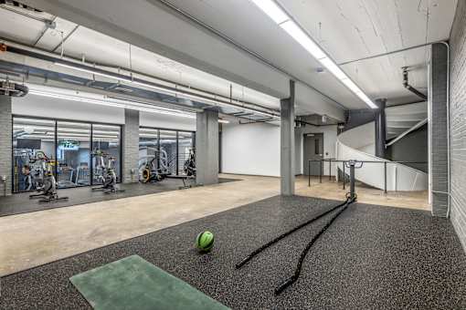 A gym with a green mat and a ball on it.