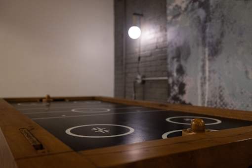 A shiny wood table with a black top and white circles and lines on it.
