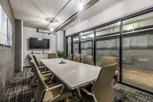 A conference room with a long table and chairs.