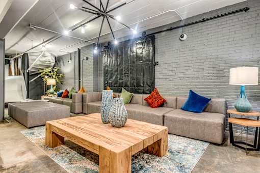 A modern living room with a wooden coffee table and grey couches.