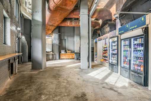 A large, empty room with a vending machine on the right side.