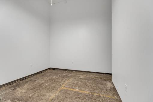 A room with a concrete floor and a white wall.