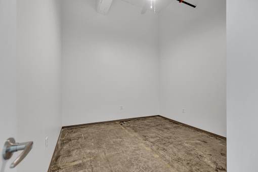 A room with a concrete floor and a ceiling fan.