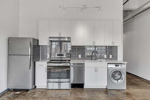 A kitchen with stainless steel appliances and white cabinets.