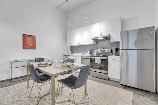 A modern kitchen with a dining table set for two.