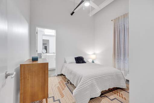 A bedroom with a bed, nightstand, and lamp.