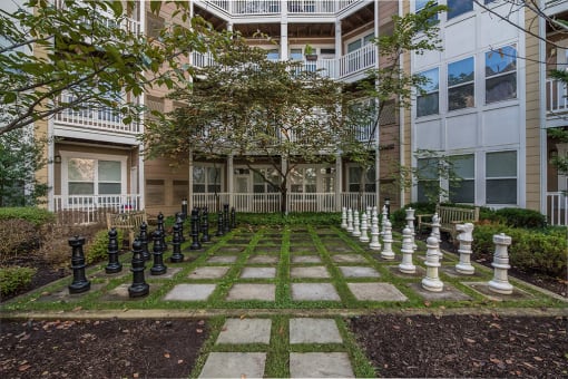 a large chess set in front of an apartment building