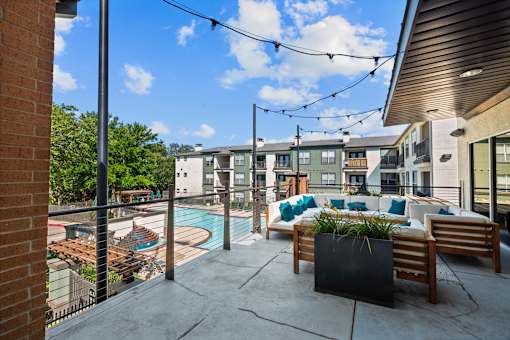 A patio with a pool and a table with chairs.