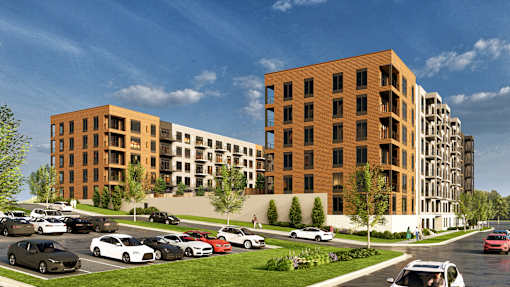 A modern apartment complex with cars parked in front.