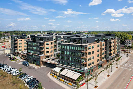 A modern building complex with a parking lot in front.