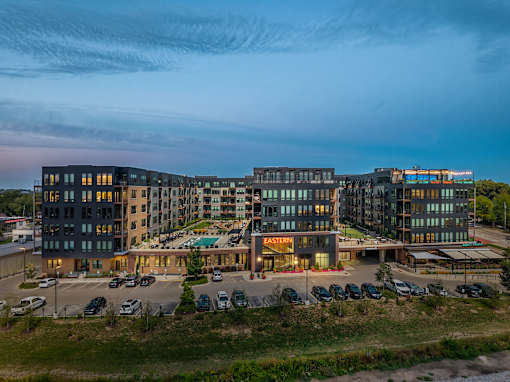 A large, modern building complex with a parking lot in front.