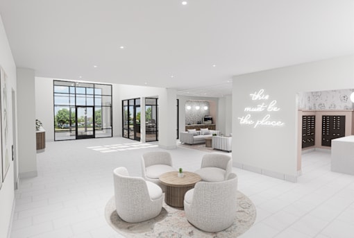 A white room with a table and chairs and a wall with the words "this must be the place".
