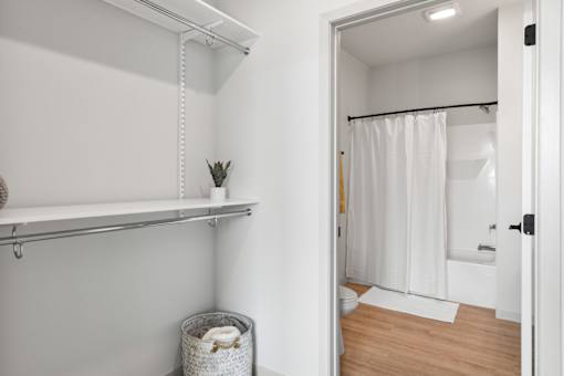 A white bathroom with a white shower curtain and a white towel.