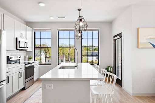 A modern kitchen with white cabinets and a large island.
