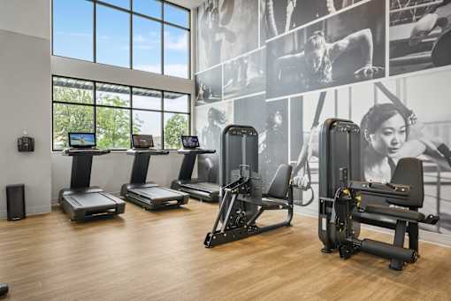 A gym with treadmills, exercise bikes and a wall of motivational posters.