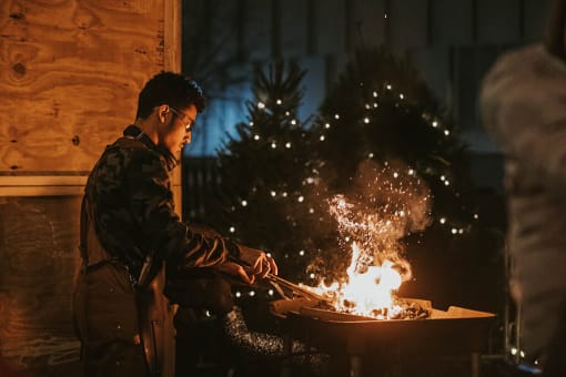 Man sitting in front of a fire at Dillard Apartments, Fargo, ND 58102