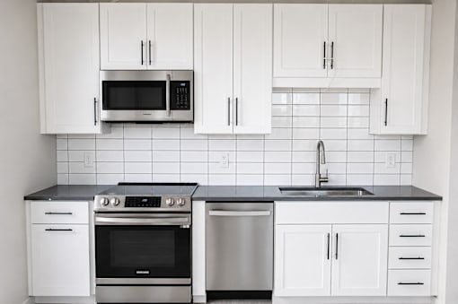 Modern kitchen with white cabinets and stainless steel appliances at The Avery - Residential Apartments, Fargo, North Dakota