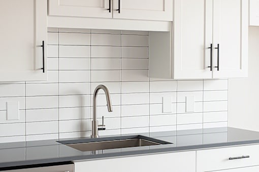 Contemporary kitchen sink and tile backsplash at The Avery - Residential Apartments, Fargo, ND