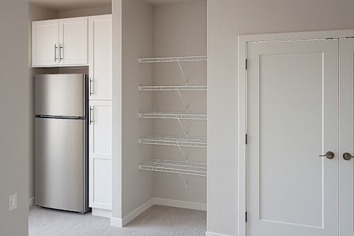 Walk in pantry with stainless steel refrigerator at The Avery - Residential Apartments, Fargo, 58102