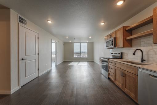 A spacious kitchen with wooden cabinets and a modern design. at Unite Apartments, Fargo, North Dakota