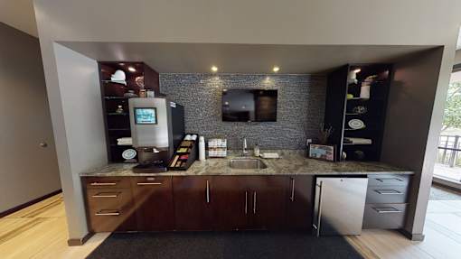 A modern kitchen with a refrigerator, sink, and cabinets.