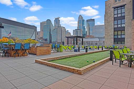 A rooftop patio with a putting green and a view of the city.