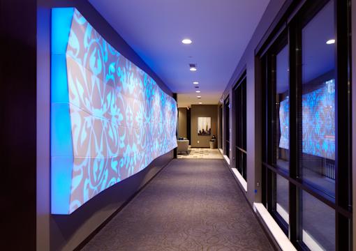 A hallway with a large screen on the wall.