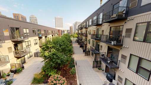 A view of a courtyard with apartment buildings on either side.