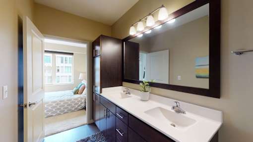A bathroom with a white sink and a mirror above it.