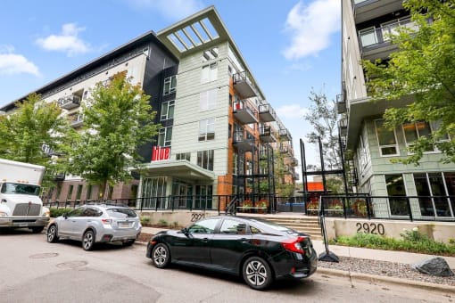 an apartment building with cars parked in front of it