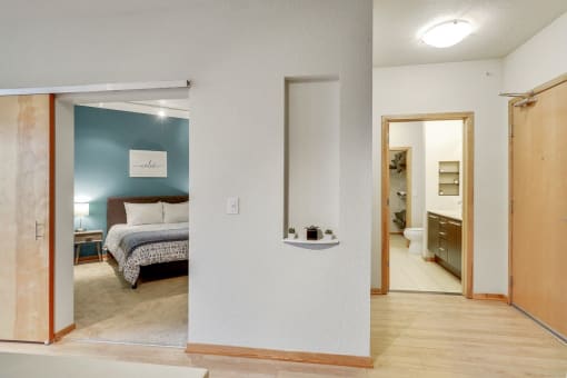 a bedroom with a bed and a bathroom with a mirror