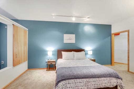 a room with a bed and a table and geometric patterns on the wall
