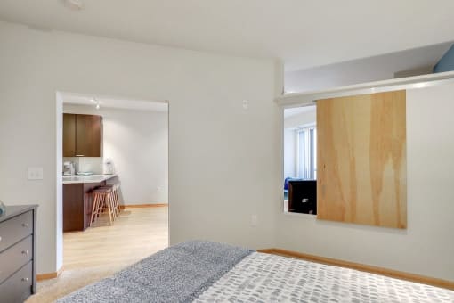 a bedroom with a bed and a doorway to a kitchen
