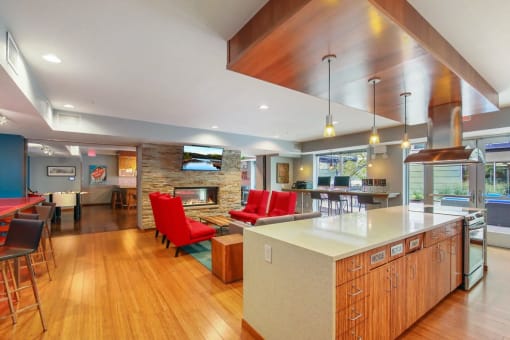a large kitchen with a bar and a living room with a fireplace