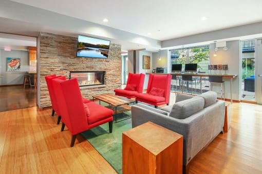a living room with red chairs and a fireplace
