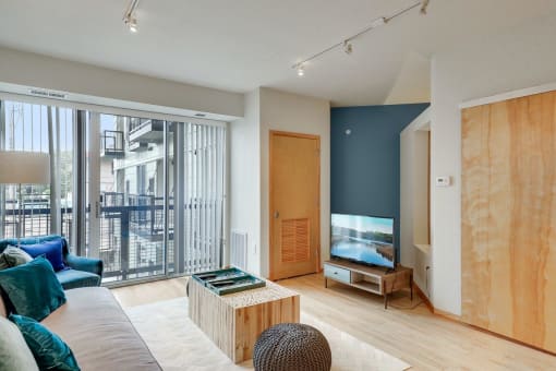 a living room with a couch and a tv and a balcony