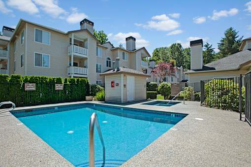 A sparkling outdoor pool here at Windsong surrounded by charming apartment buildings and lush greenery. This bright and inviting space offers clear blue water, a relaxing hot tub, and a peaceful setting perfect for enjoying sunny days.