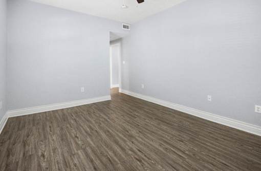 A room with wooden flooring and a white door.