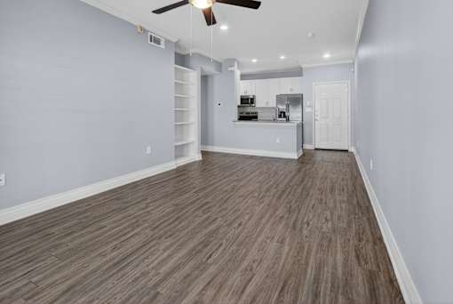 A room with wooden flooring and a ceiling fan.