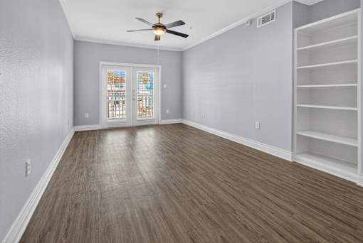 A room with a ceiling fan and a window with blinds.
