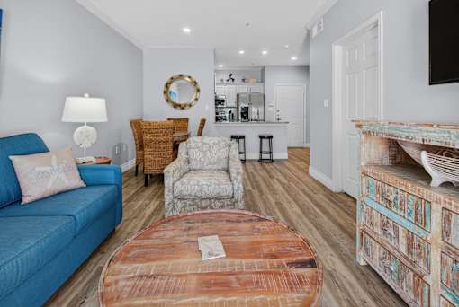 A living room with a blue couch and a wooden coffee table.