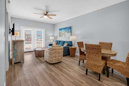 A living room with a ceiling fan and a painting on the wall.