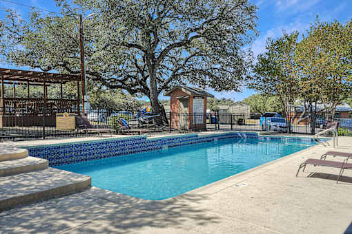 Modern swimming pool with lounge seating at Sierra Ranch Apartments in San Antonio, TX.