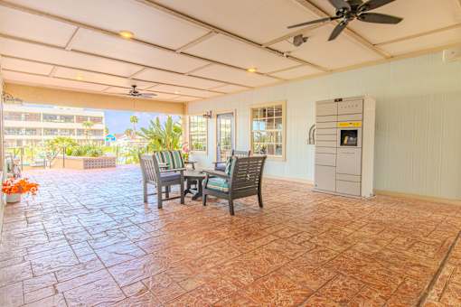 A patio with a table and chairs and a fan.