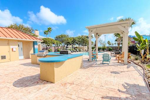A pool area with a white pergola and a blue pool table.