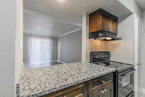 Apartment kitchen featuring upgraded appliances and lighting