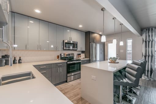 Designer kitchen with quartz countertops and stainless-steel appliances in Dallas apartment