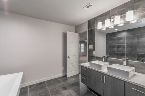 Modern bathroom with sleek tile design and large vanity at Reserve on Abrams
