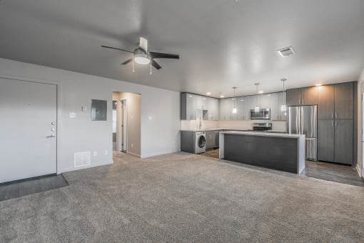 Modern open-concept living room with ceiling fan and wood-style floors at Reserve on Abrams Dallas